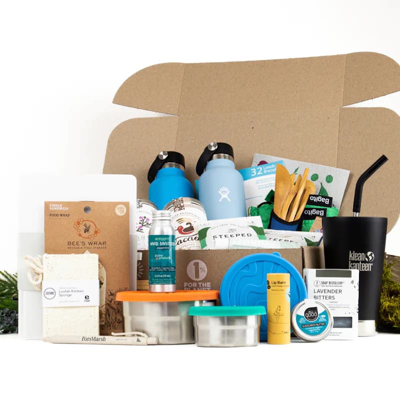 A cardboard box full of eco-friendly products, including Bee's Wrap, a loofah, stainlees steel food storage tins, Kleen Kanteen reusable beverage containers, bamboo cutlery, and more from sustainable online marketplace EarthHero.