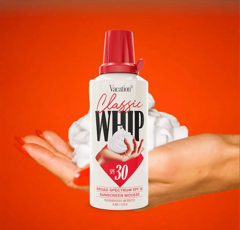 A hand with long red fingernails holds what looks like a puff of whipped cream; a can in front that looks like a whipped cream can says Vacation Classic Whip SPF 30.
