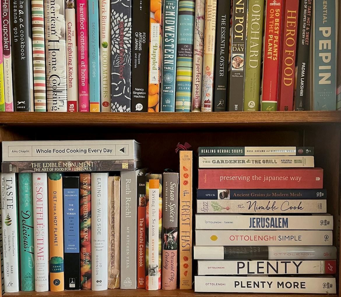 A bookshelf containing cookbooks and books about food.