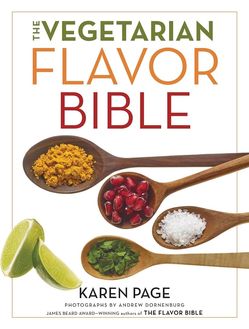A white cookbook cover, with the words, The Vegetarian Flavor Bible by Karen Page on the cover along with four wooden spoons full of spices and two slices of limes.