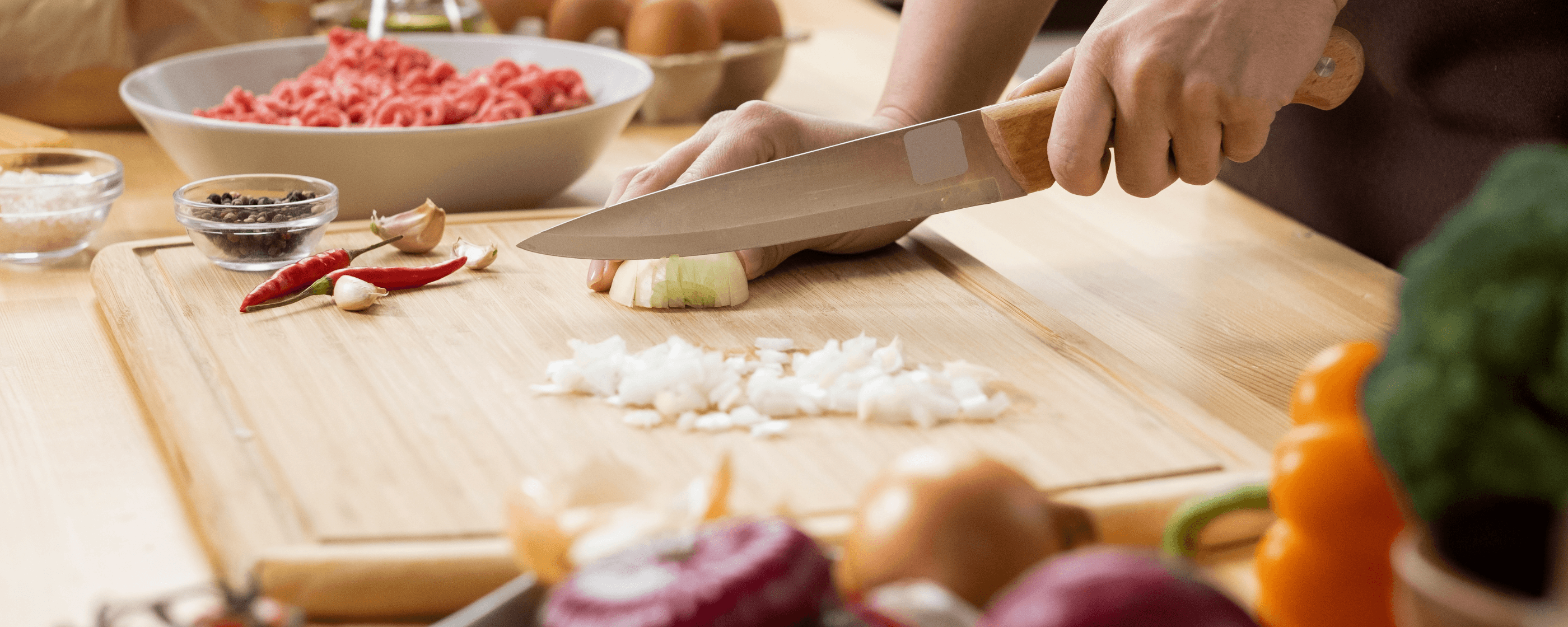 Hands cutting vegetables in the kitchen.