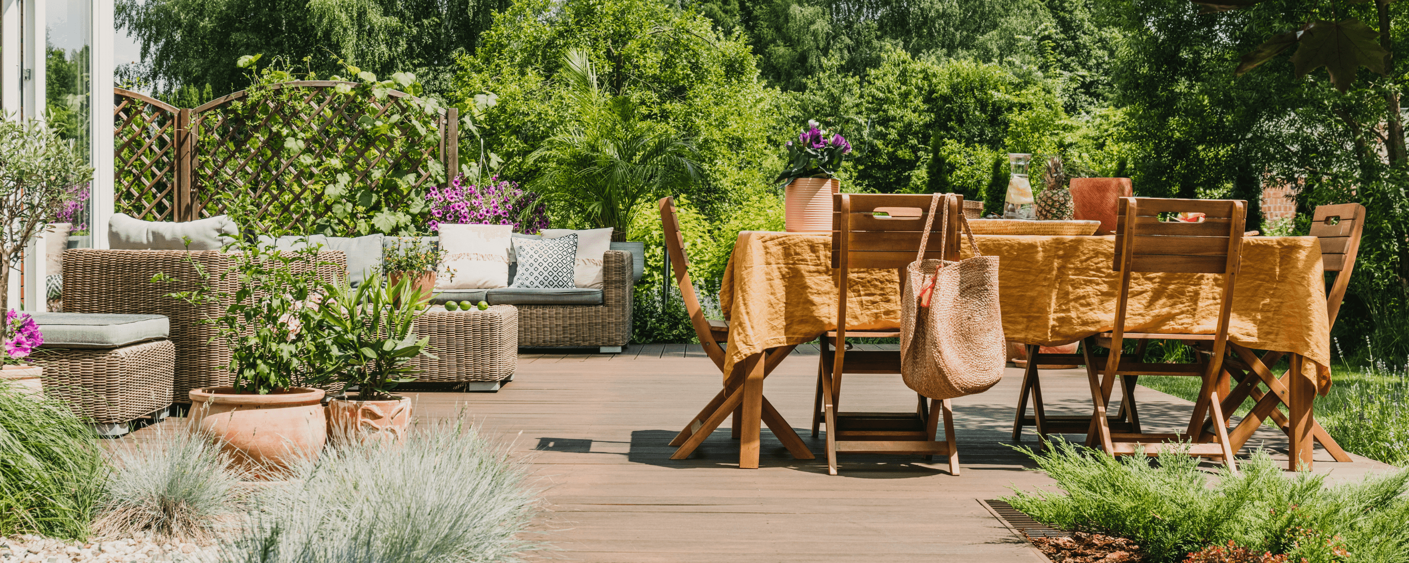 An outdoor patio with furniture surrounded by gardens.