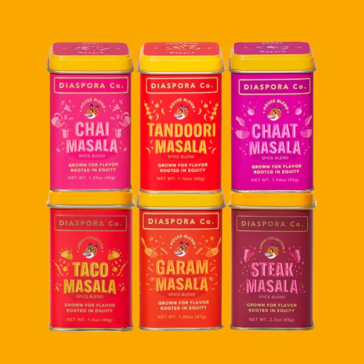 Six colorful tins of spices from Diaspora Co.: Chai Masala, Tandoor Masala, Chaat Masala, Taco Masala, Garam Masala, Steak Masala