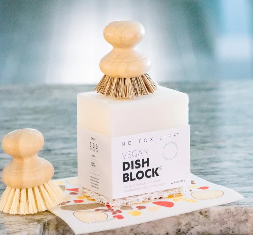 a white block of soap and a dish scrubber, with a box labeled No Tox Life Vegan Soap Block