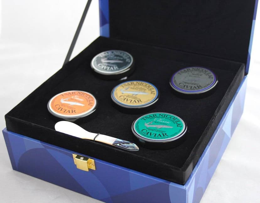 An attractive, velvet-lined hinged box containing an assortment of five kinds of Tsar Nicoulai caviar and a mother-of-pearl spoon.