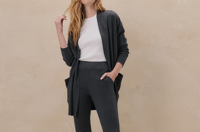 A blonde woman wears a matching grey cotton jacket and pants with a tee-shirt.