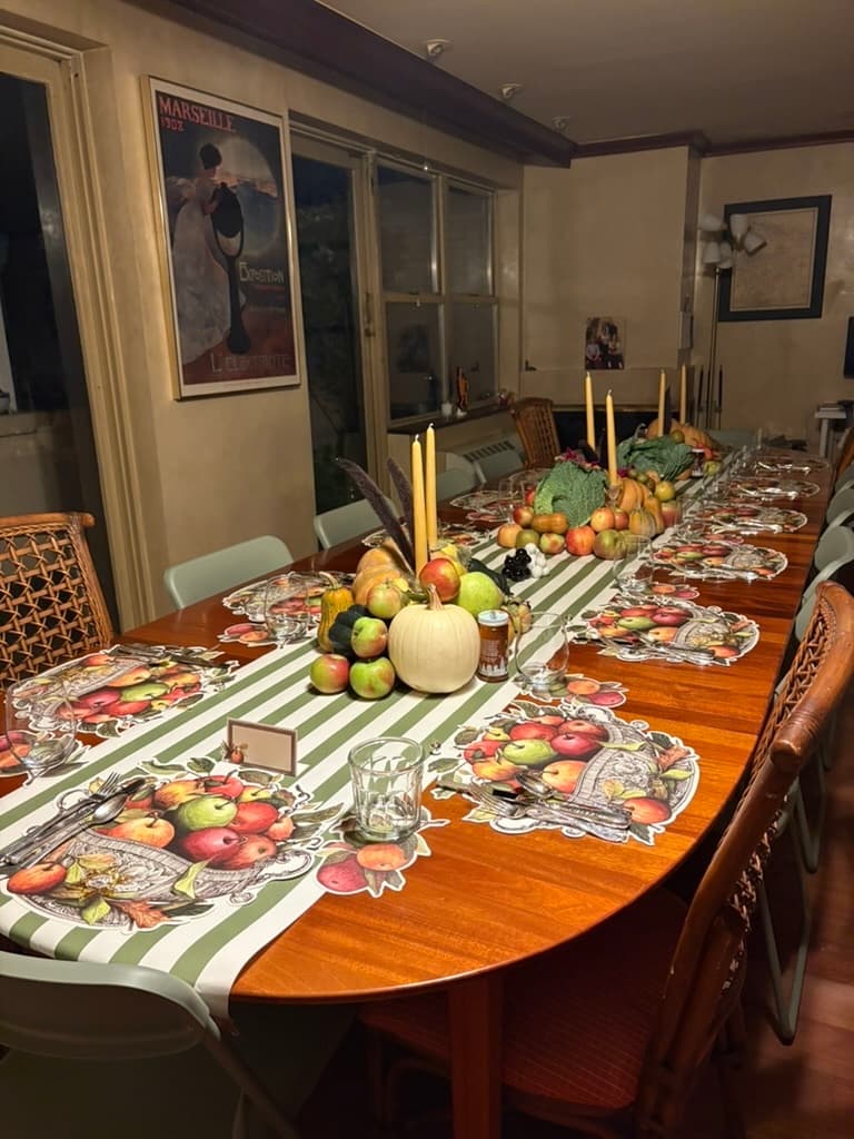 A table set with candles and apple-themed placemats